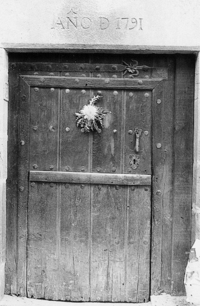 foto antigua de puerta de casa con ramo en la puerta casas San Juan